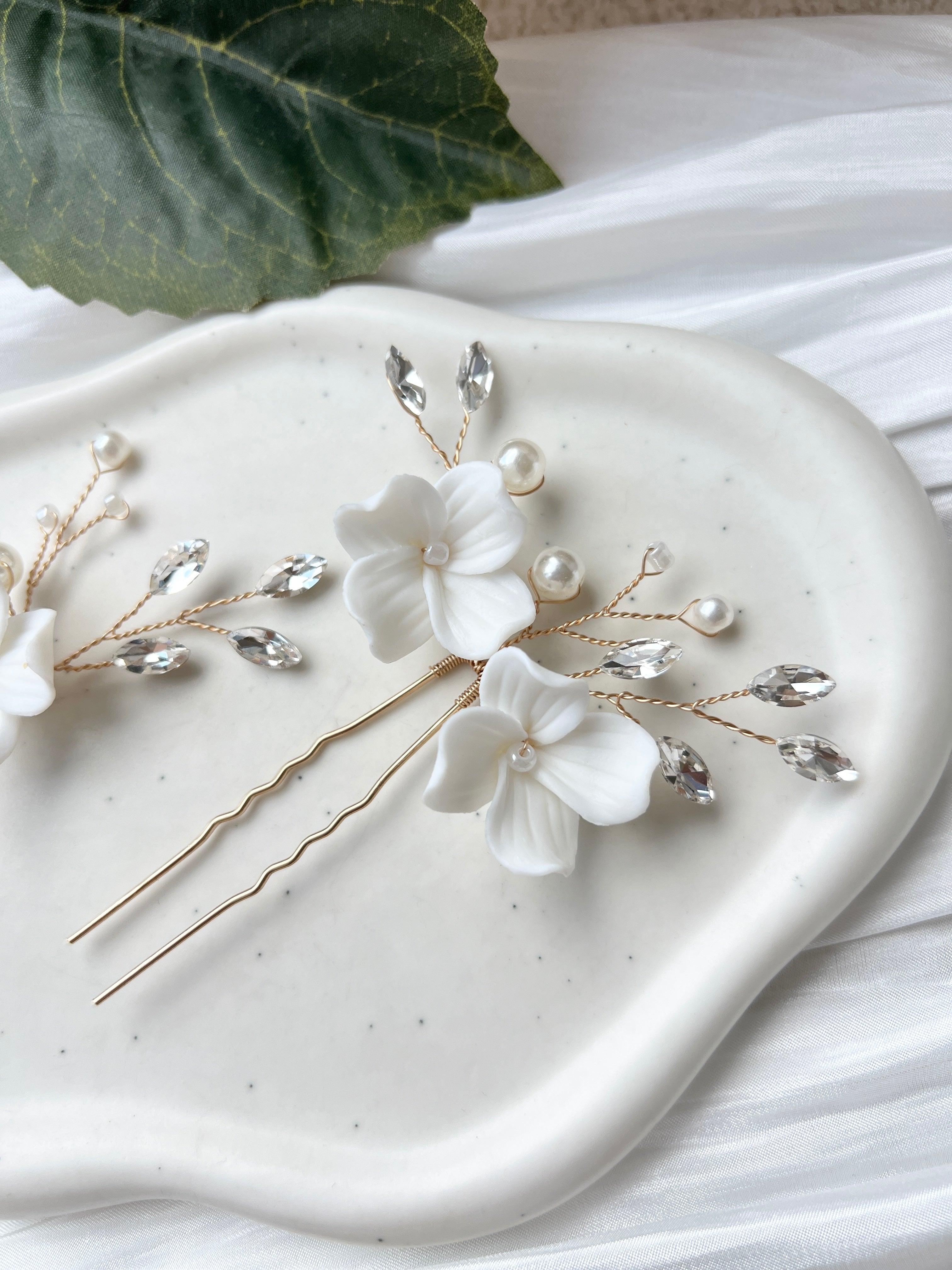 Feine Haarnadeln, Set 2 Stueck, Blumen aus Keramik, feiner goldener Schmuck, Haarschmuck fuer die Brautfrisur, weisser Bluetenschmuck, zarte Perlen und Strasssteine, eleganter Brautschmuck, moderner Perlenschmuck, luxurioeser Brauthaarschmuck, Perlenhaarschmuck, hochwertiger Hochzeitsschmuck, Schmuck Hochzeit, Weddinginspiration