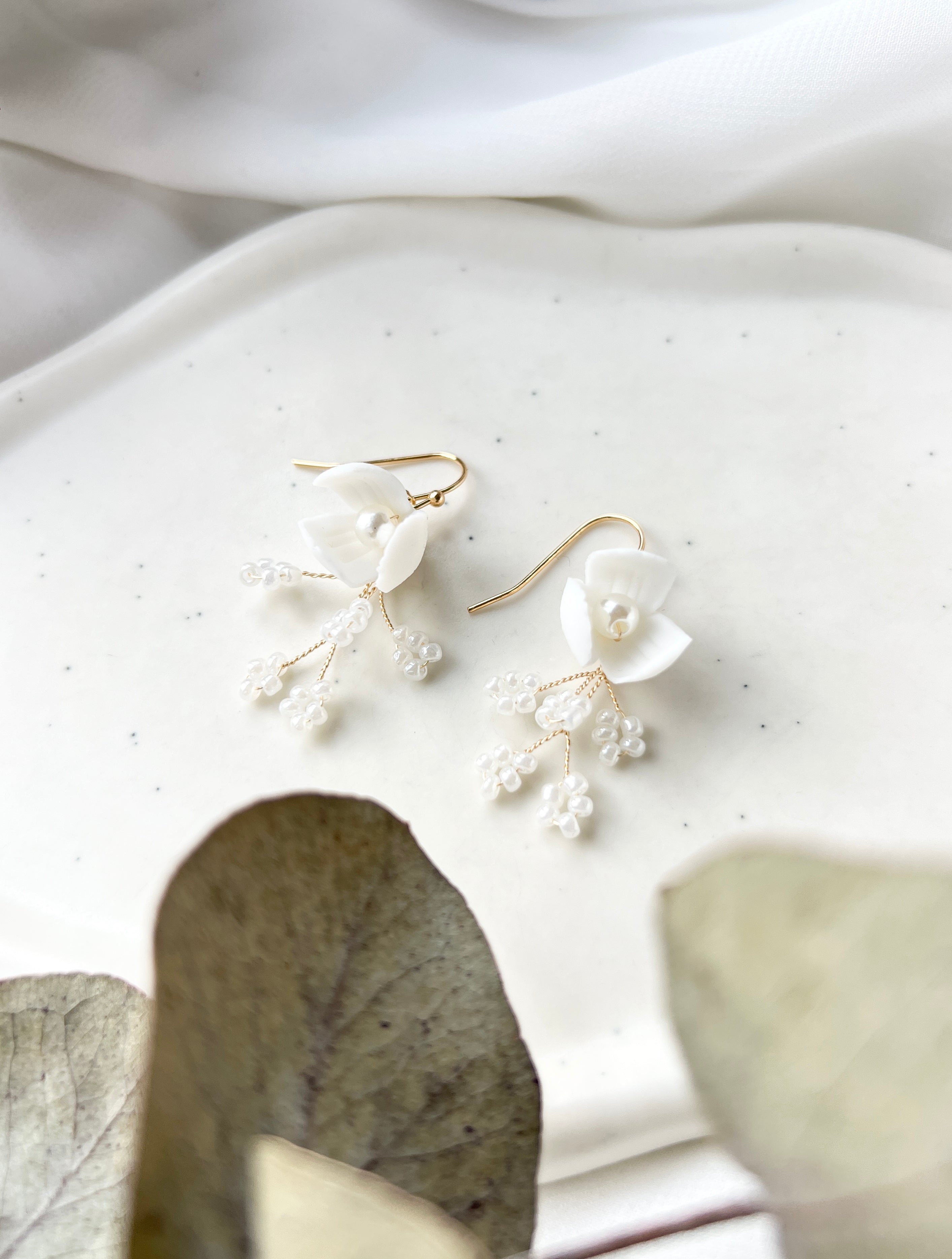 Feine handgefertigte Brautohrringe, zarte Keramikblumen und elegante kleine Perlen, goldener Juwelierdraht, Hochzeitsschmuck fuer die moderne Braut, Ohrringe, Schmuck Hochzeit, feinster Brautschmuck, hochwertige Verarbeitung, Weddinginspiration