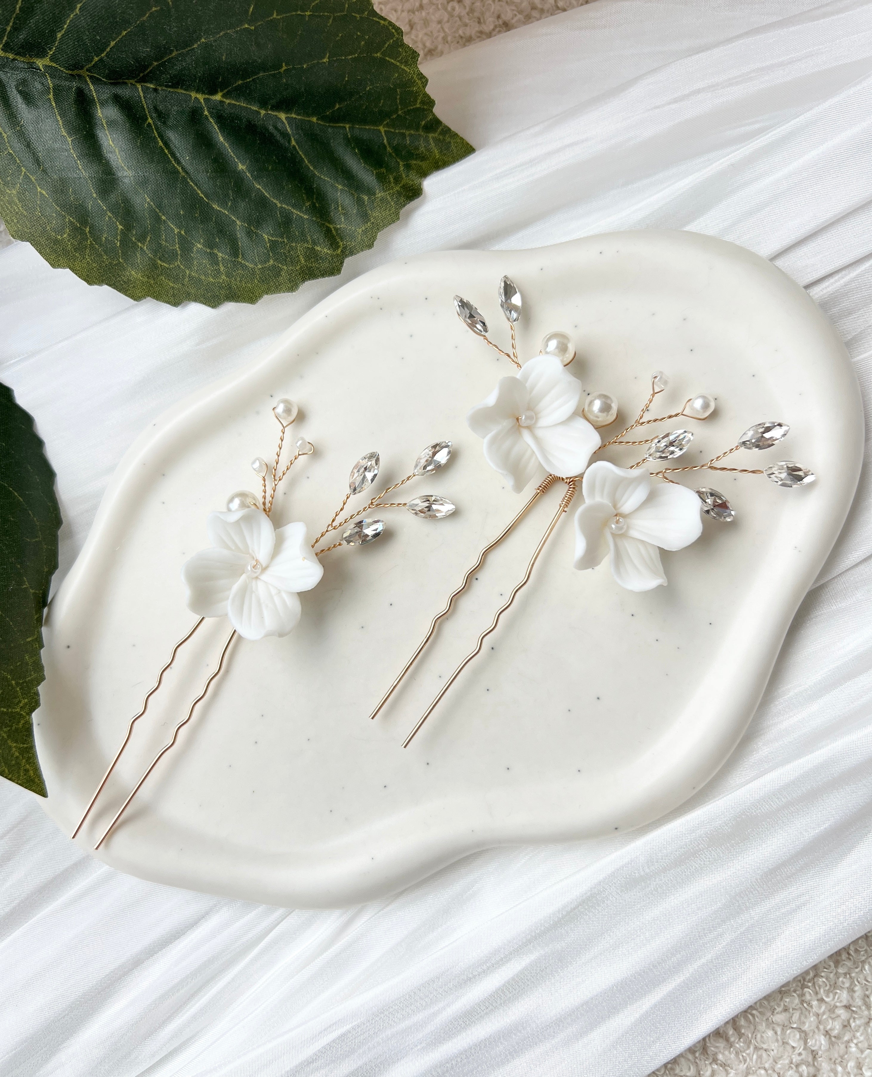 Feine Haarnadeln, Set 2 Stueck, Blumen aus Keramik, feiner goldener Schmuck, Haarschmuck fuer die Brautfrisur, weisser Bluetenschmuck, zarte Perlen und Strasssteine, eleganter Brautschmuck, moderner Perlenschmuck, luxurioeser Brauthaarschmuck, Perlenhaarschmuck, hochwertiger Hochzeitsschmuck, Schmuck Hochzeit, Weddinginspiration
