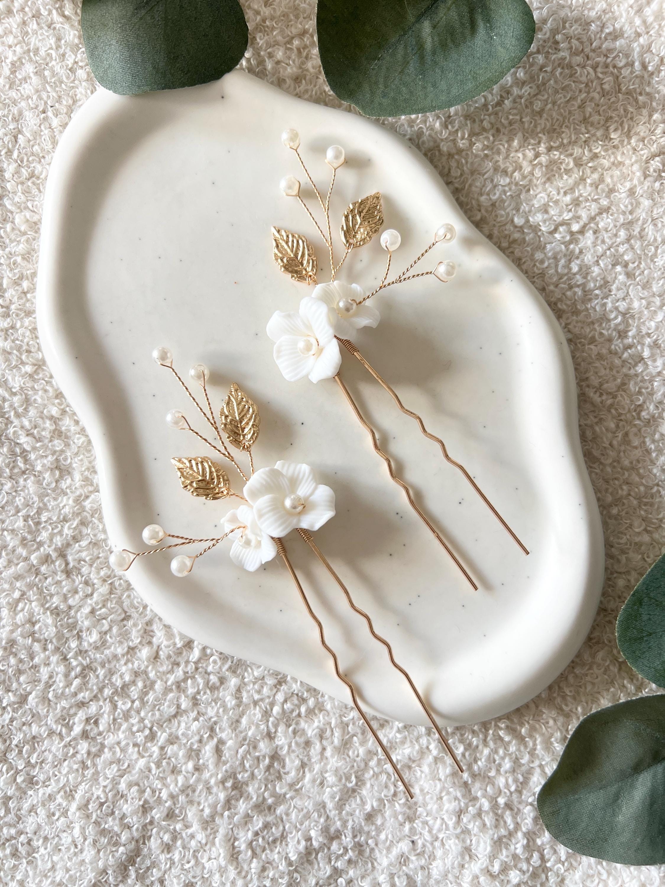 Feine Haarnadeln, Set 2 Stueck, Blumen aus Keramik, feiner goldener Schmuck, Haarschmuck fuer die Brautfrisur, weisser Bluetenschmuck, zarte Perlen und Strasssteine, eleganter Brautschmuck, moderner Perlenschmuck, luxurioeser Brauthaarschmuck, Perlenhaarschmuck, hochwertiger Hochzeitsschmuck, Schmuck Hochzeit, Weddinginspiration
