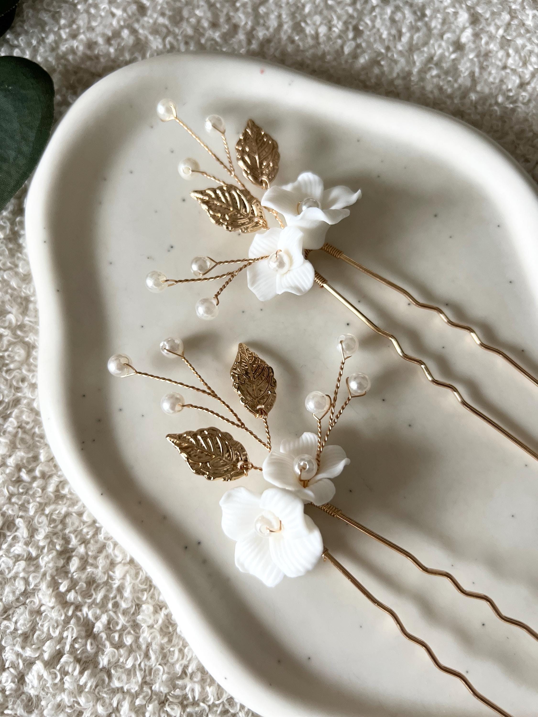 Feine Haarnadeln, Set 2 Stueck, Blumen aus Keramik, feiner goldener Schmuck, Haarschmuck fuer die Brautfrisur, weisser Bluetenschmuck, zarte Perlen und Strasssteine, eleganter Brautschmuck, moderner Perlenschmuck, luxurioeser Brauthaarschmuck, Perlenhaarschmuck, hochwertiger Hochzeitsschmuck, Schmuck Hochzeit, Weddinginspiration