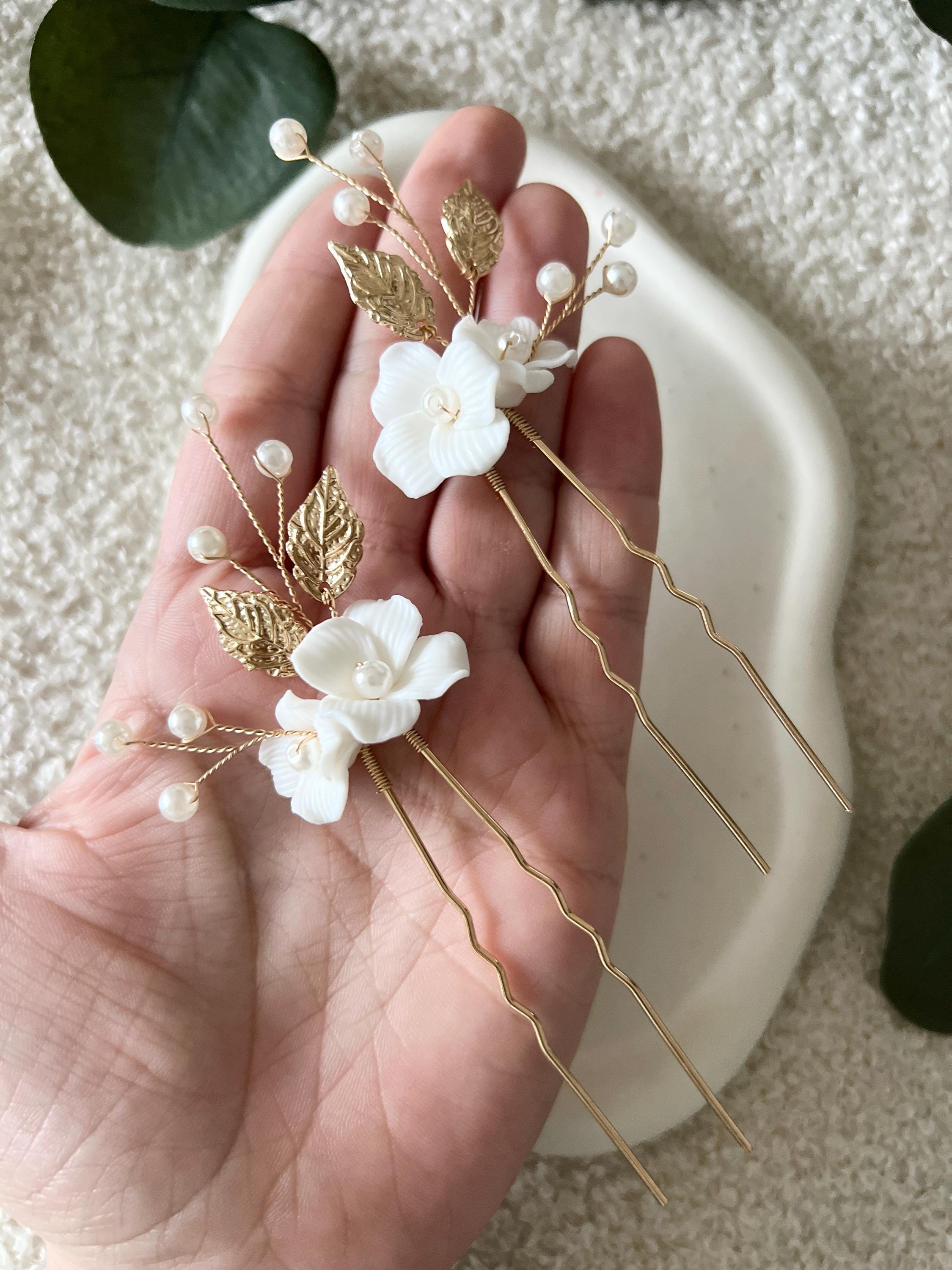 Feine Haarnadeln, Set 2 Stueck, Blumen aus Keramik, feiner goldener Schmuck, Haarschmuck fuer die Brautfrisur, weisser Bluetenschmuck, zarte Perlen und Strasssteine, eleganter Brautschmuck, moderner Perlenschmuck, luxurioeser Brauthaarschmuck, Perlenhaarschmuck, hochwertiger Hochzeitsschmuck, Schmuck Hochzeit, Weddinginspiration