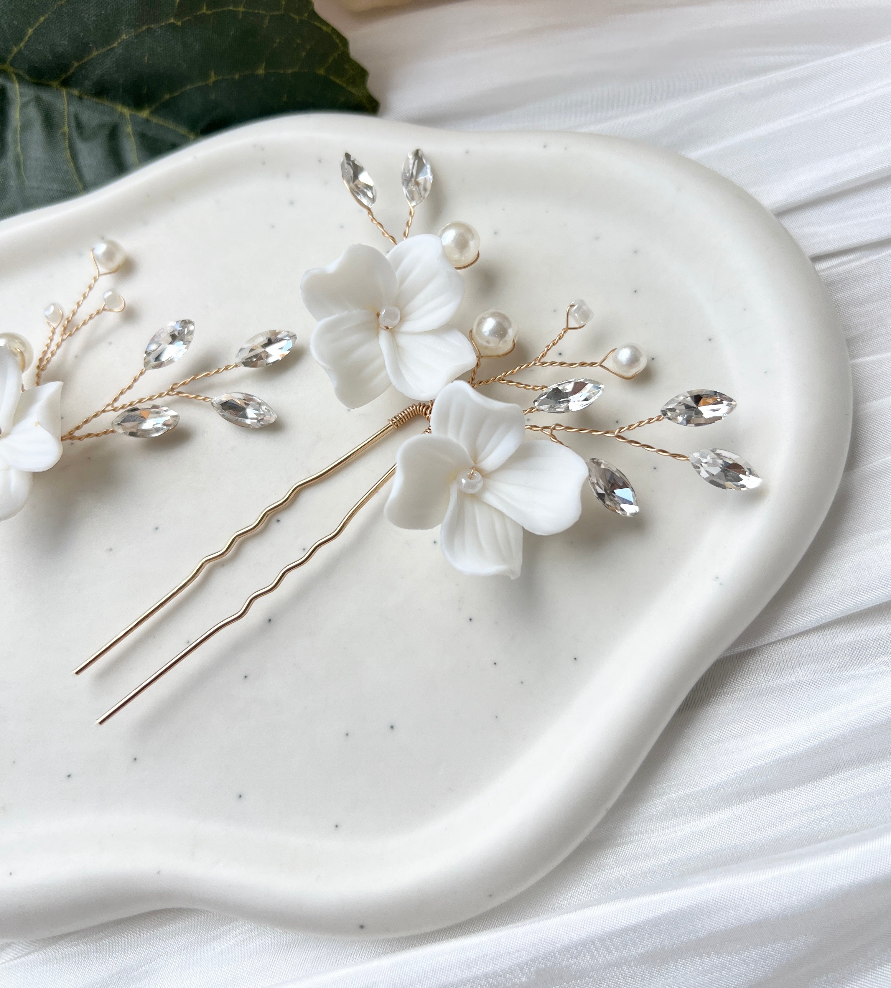 Feine Haarnadeln, Set 2 Stueck, Blumen aus Keramik, feiner goldener Schmuck, Haarschmuck fuer die Brautfrisur, weisser Bluetenschmuck, zarte Perlen und Strasssteine, eleganter Brautschmuck, moderner Perlenschmuck, luxurioeser Brauthaarschmuck, Perlenhaarschmuck, hochwertiger Hochzeitsschmuck, Schmuck Hochzeit, Weddinginspiration