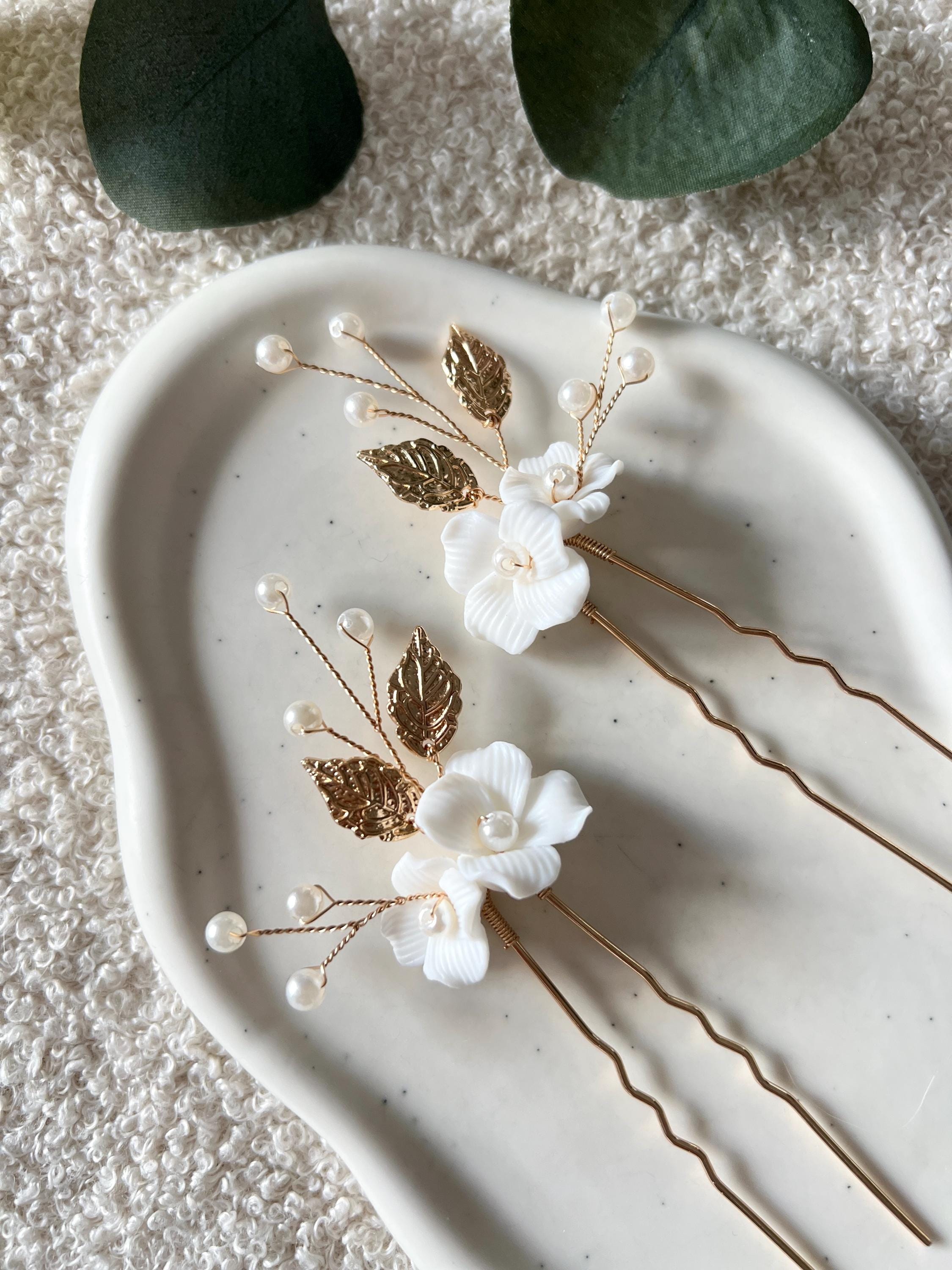Feine Haarnadeln, Set 2 Stueck, Blumen aus Keramik, feiner goldener Schmuck, Haarschmuck fuer die Brautfrisur, weisser Bluetenschmuck, zarte Perlen und Strasssteine, eleganter Brautschmuck, moderner Perlenschmuck, luxurioeser Brauthaarschmuck, Perlenhaarschmuck, hochwertiger Hochzeitsschmuck, Schmuck Hochzeit, Weddinginspiration