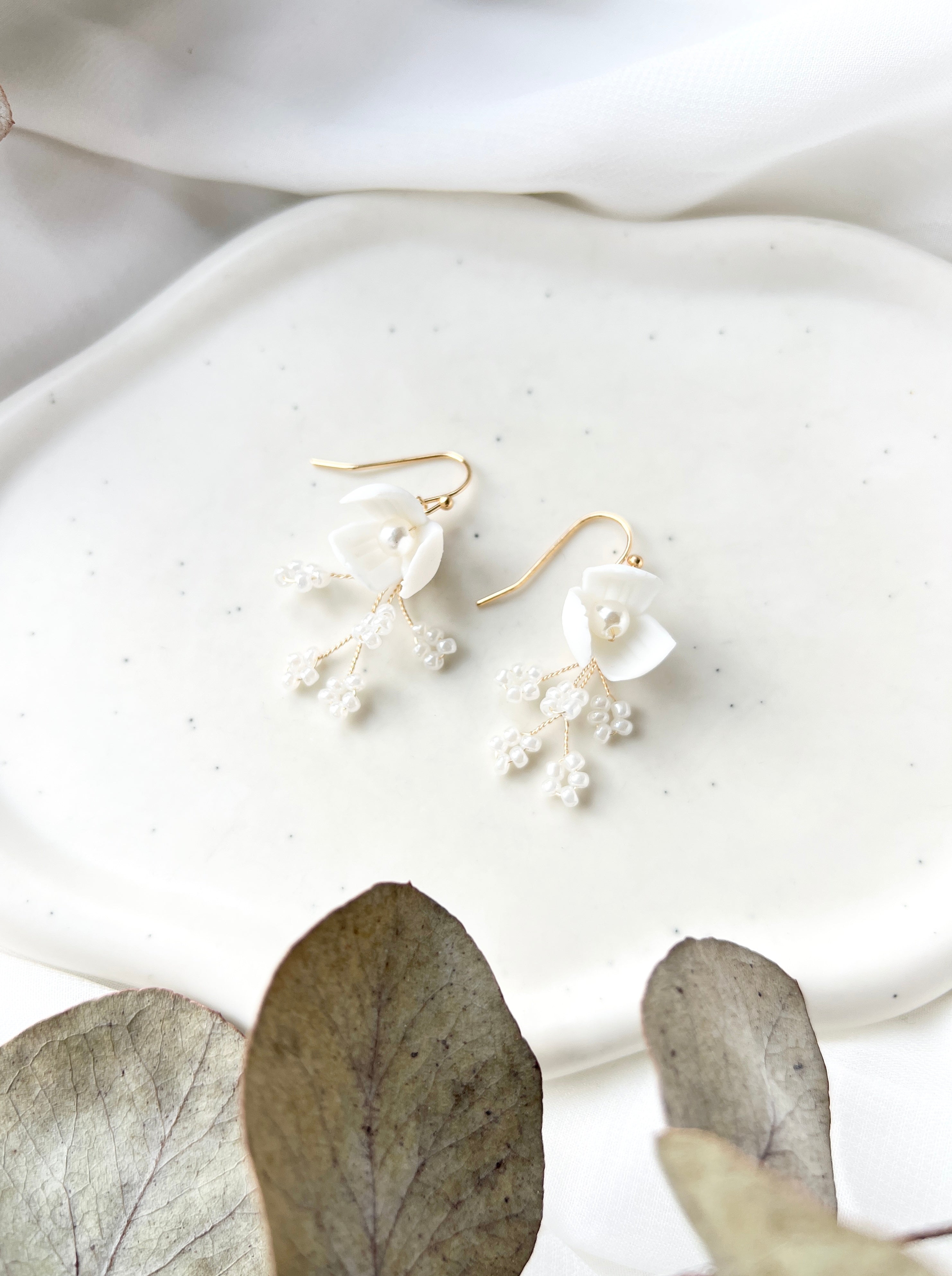 Feine handgefertigte Brautohrringe, zarte Keramikblumen und elegante kleine Perlen, goldener Juwelierdraht, Hochzeitsschmuck fuer die moderne Braut, Ohrringe, Schmuck Hochzeit, feinster Brautschmuck, hochwertige Verarbeitung, Weddinginspiration