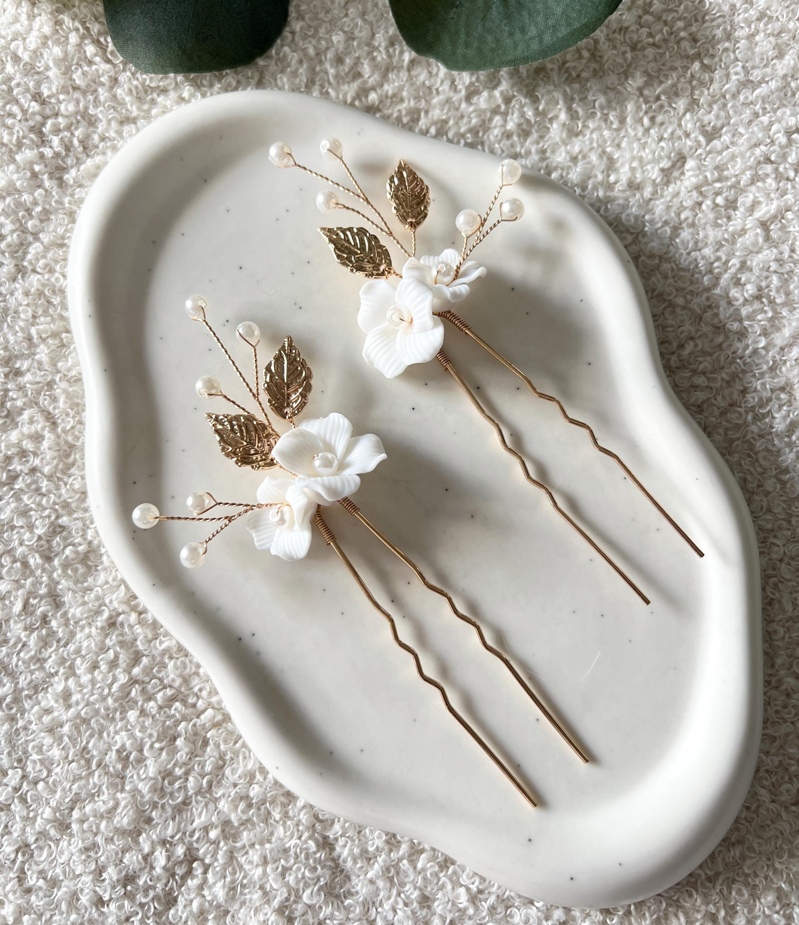 Feine Haarnadeln, Set 2 Stueck, Blumen aus Keramik, feiner goldener Schmuck, Haarschmuck fuer die Brautfrisur, weisser Bluetenschmuck, zarte Perlen und Strasssteine, eleganter Brautschmuck, moderner Perlenschmuck, luxurioeser Brauthaarschmuck, Perlenhaarschmuck, hochwertiger Hochzeitsschmuck, Schmuck Hochzeit, Weddinginspiration