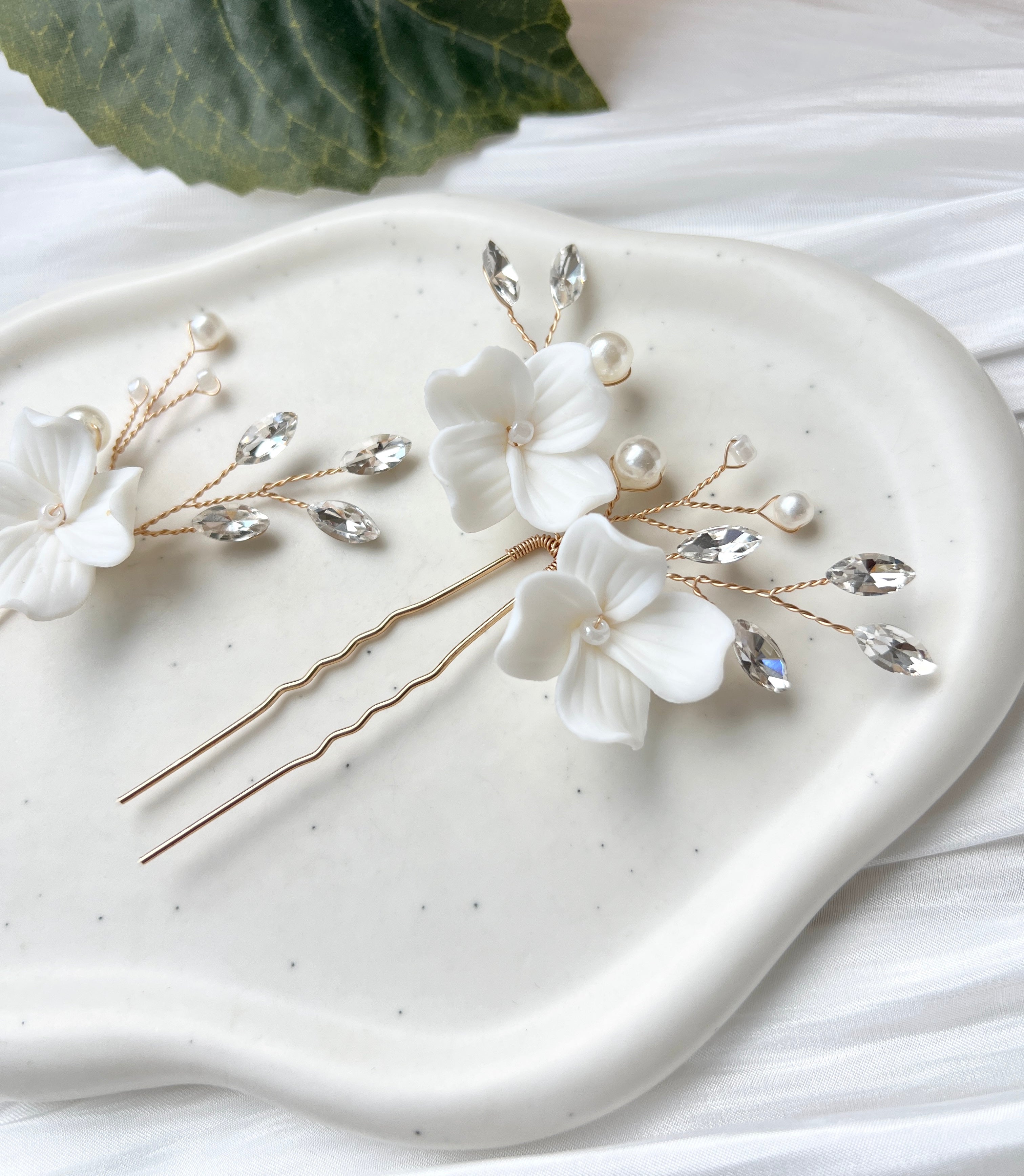 Feine Haarnadeln, Set 2 Stueck, Blumen aus Keramik, feiner goldener Schmuck, Haarschmuck fuer die Brautfrisur, weisser Bluetenschmuck, zarte Perlen und Strasssteine, eleganter Brautschmuck, moderner Perlenschmuck, luxurioeser Brauthaarschmuck, Perlenhaarschmuck, hochwertiger Hochzeitsschmuck, Schmuck Hochzeit, Weddinginspiration