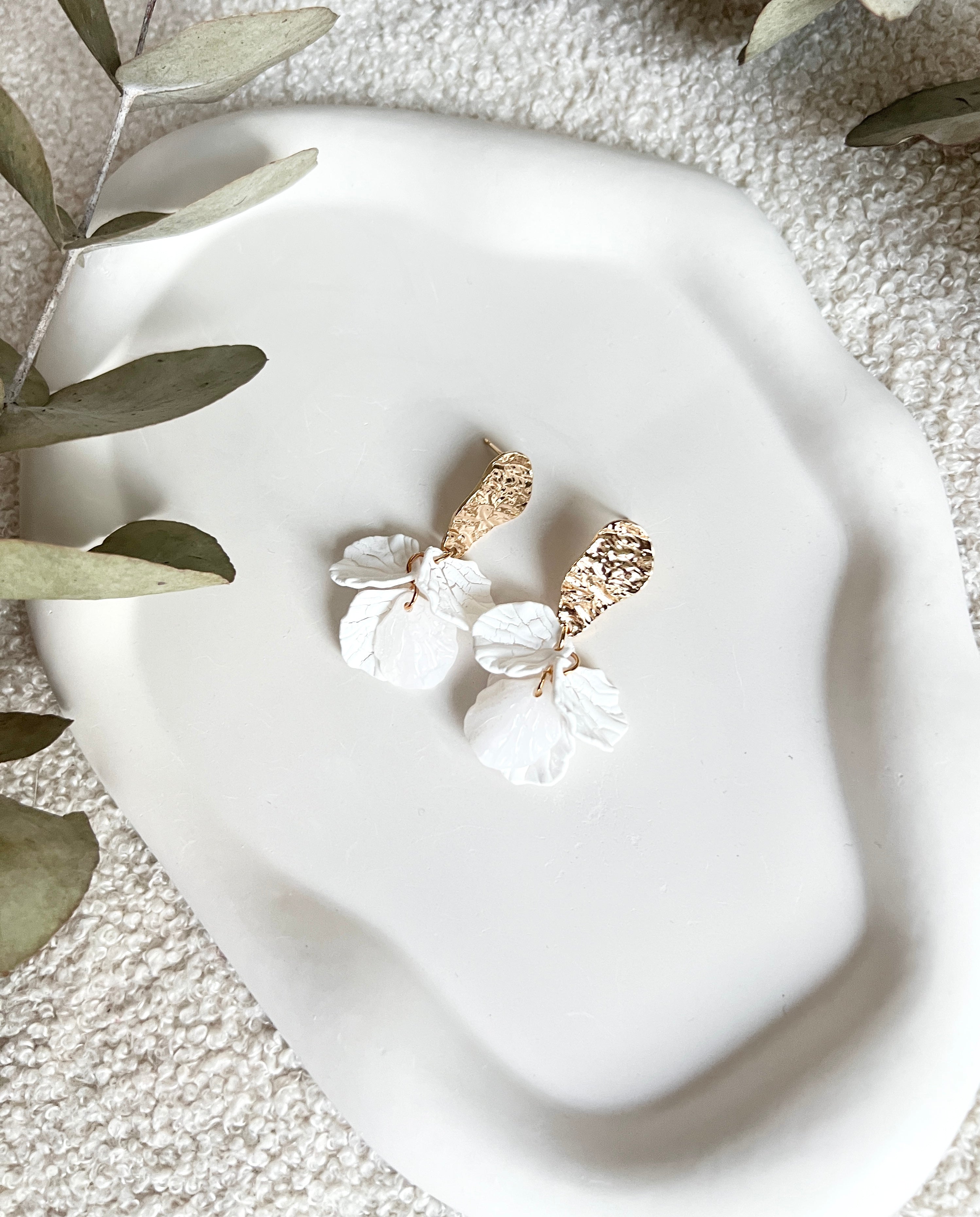 Brautohrringe, Gold und Weiss, Blaetterform, feine Ohrringe, moderner Brautschmuck, Ohrstecker mit goldenen Details, Bluetenblätter, Schmuck Hochzeit, elegante Haengeohrringe, Trauzeugin oder Brautjungfer, Brautlook, Weddinginspiration, Schmuckbluete