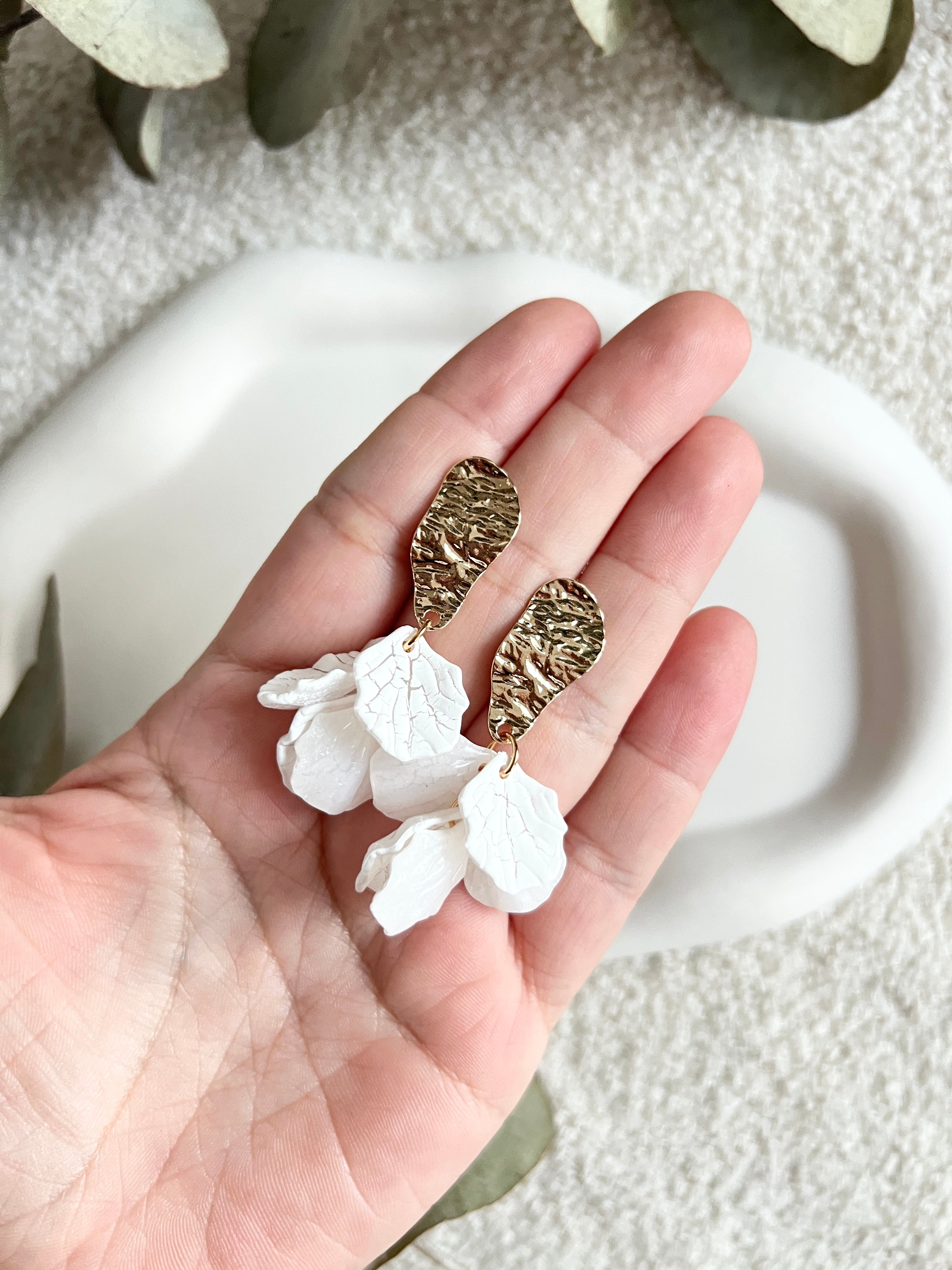 Brautohrringe, Gold und Weiss, Blaetterform, feine Ohrringe, moderner Brautschmuck, Ohrstecker mit goldenen Details, Bluetenblätter, Schmuck Hochzeit, elegante Haengeohrringe, Trauzeugin oder Brautjungfer, Brautlook, Weddinginspiration, Schmuckbluete