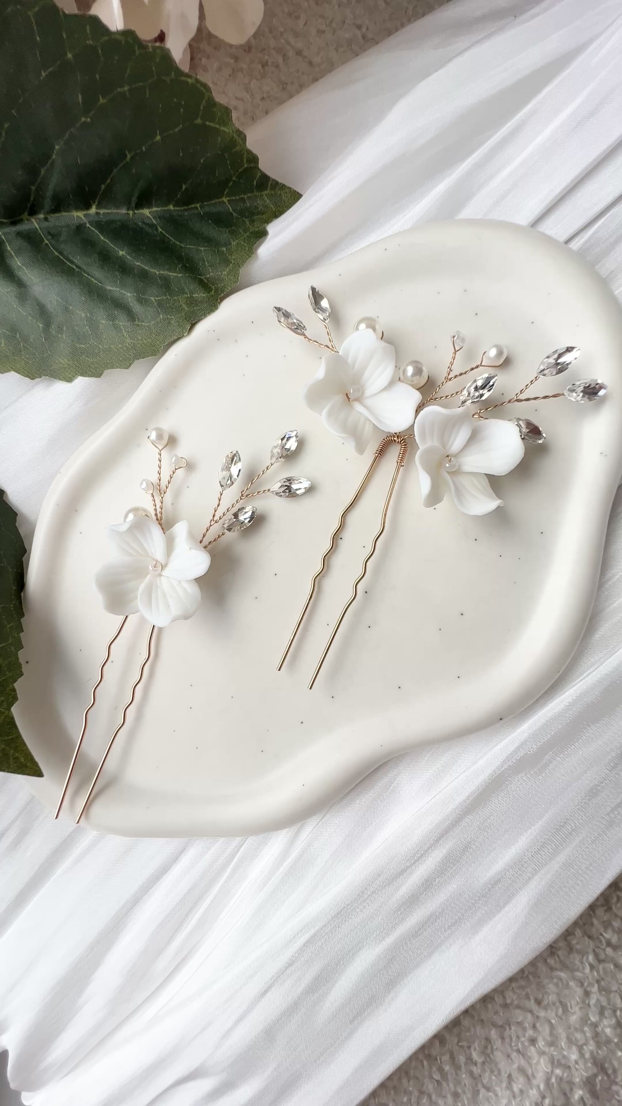 Feine Haarnadeln, Set 2 Stueck, Blumen aus Keramik, feiner goldener Schmuck, Haarschmuck fuer die Brautfrisur, weisser Bluetenschmuck, zarte Perlen und Strasssteine, eleganter Brautschmuck, moderner Perlenschmuck, luxurioeser Brauthaarschmuck, Perlenhaarschmuck, hochwertiger Hochzeitsschmuck, Schmuck Hochzeit, Weddinginspiration